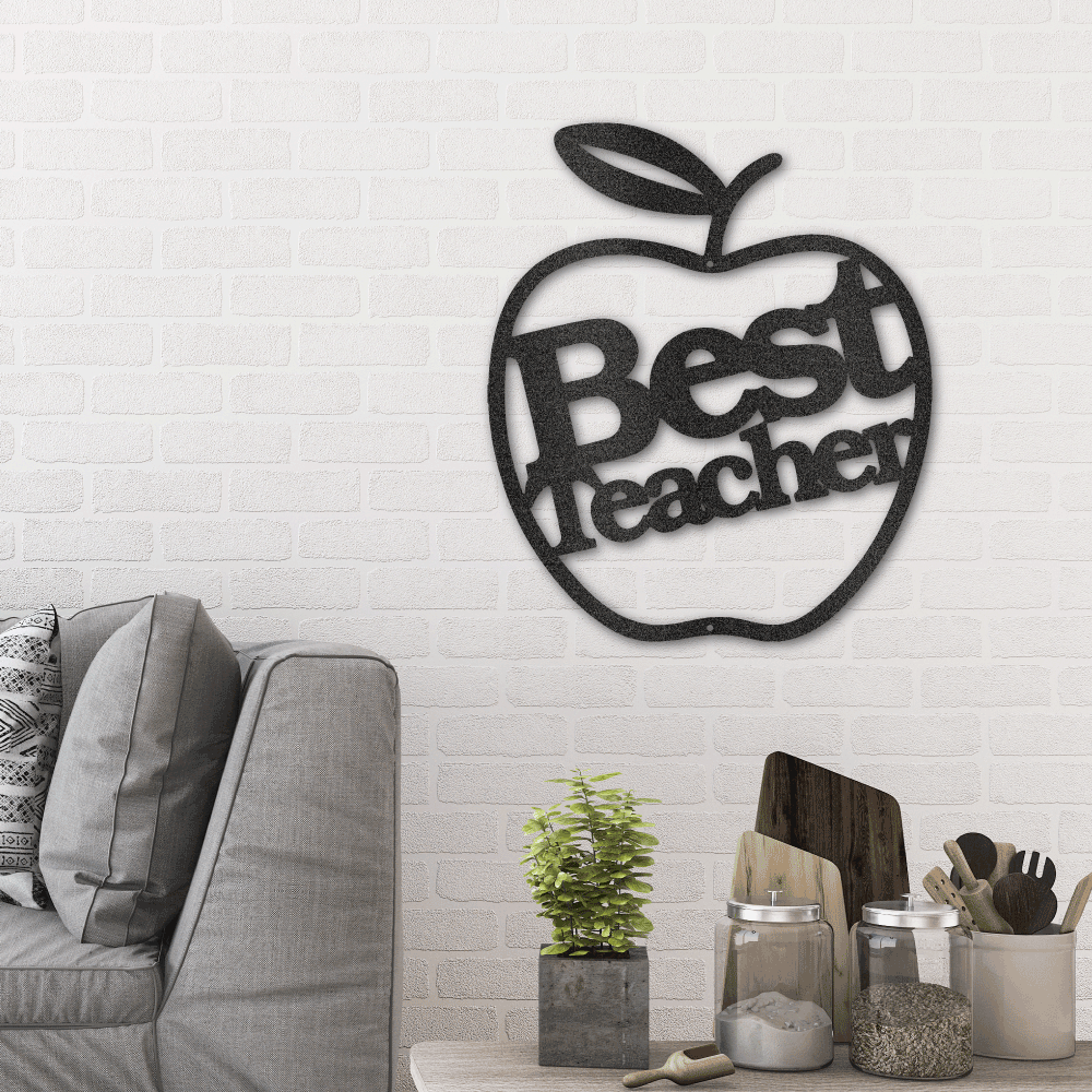 Metal wall art sign of an apple with the message Best Teacher to gift this as a appreciation gift. This picture shows the design in the color black. Hanging on the wall in a living room above a couch.